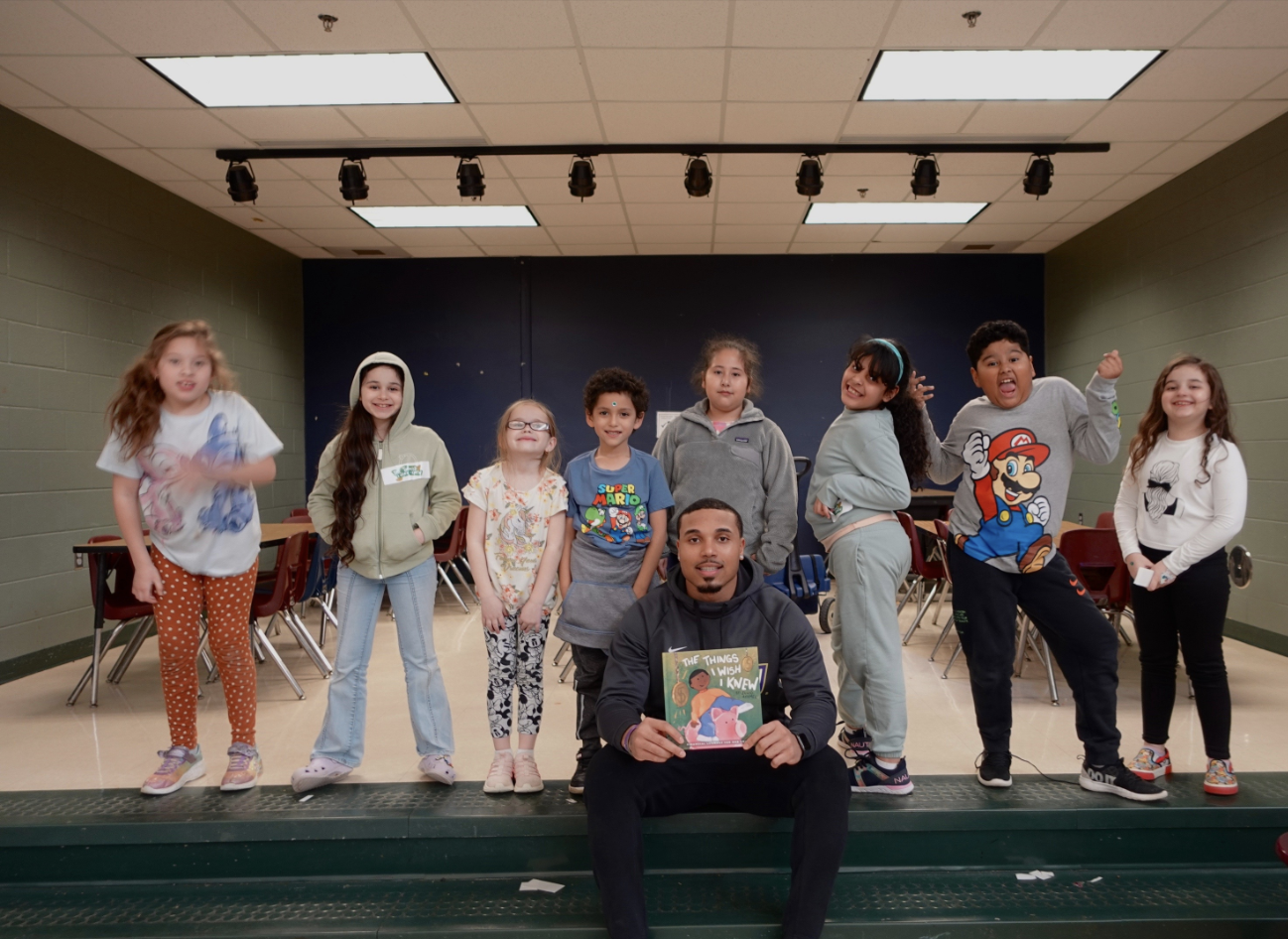 Julio Ayamel with students holding The Things I Wish I Knew books